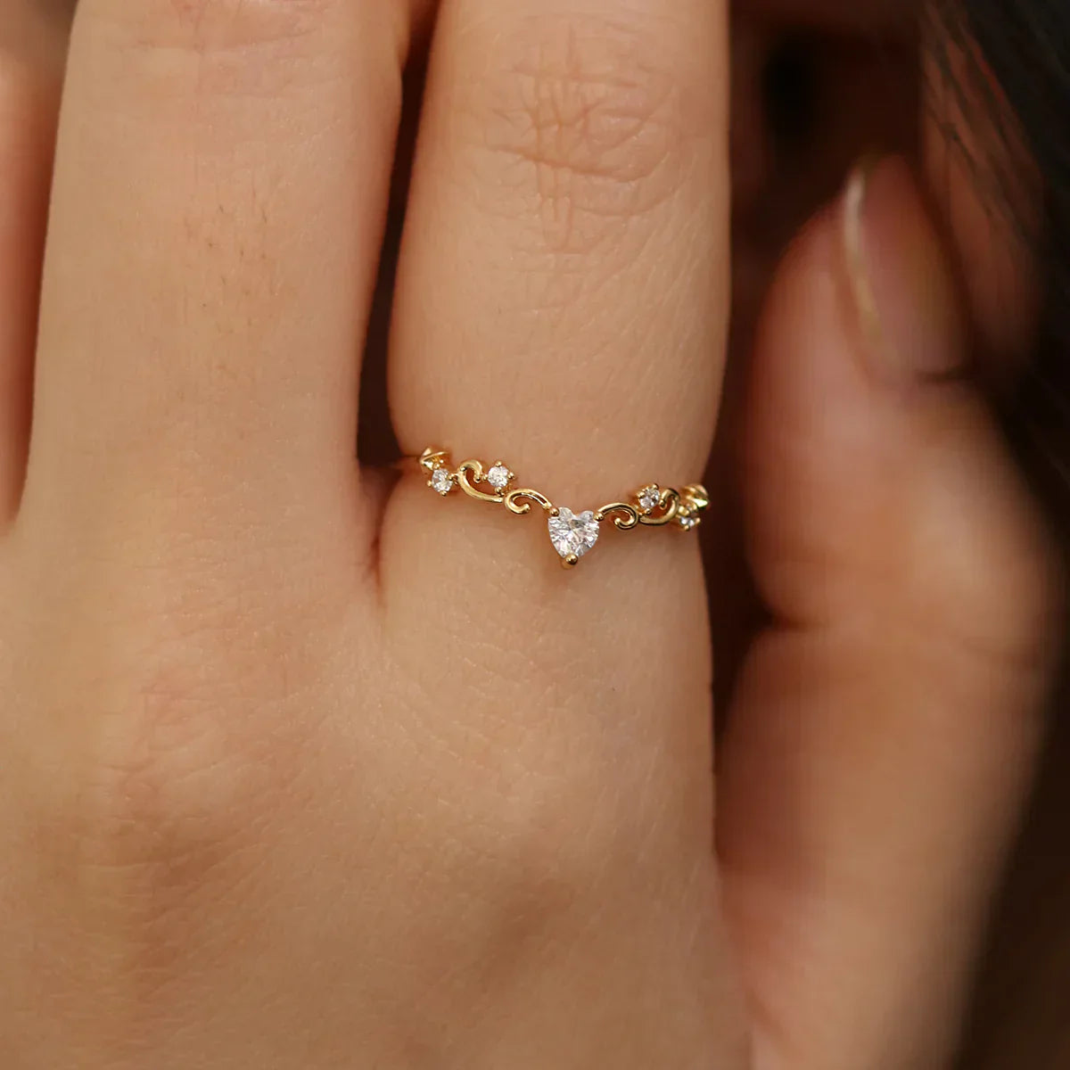 A close-up of a hand wearing Nabilondon’s elegant heart ring, featuring a heart-shaped white topaz at the centre. A dainty and timeless bestseller, perfect for adding a romantic touch.